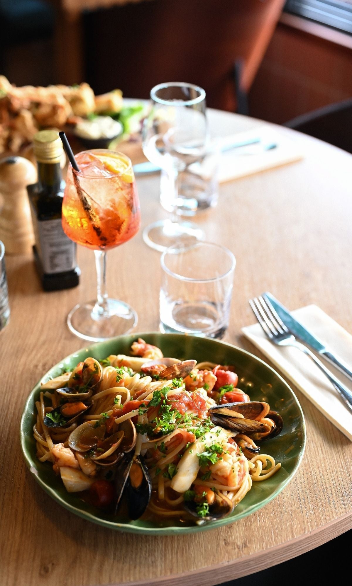 Plat de pâtes aux fruits de mer accompagné d’un cocktail chez Scusi au Lavandou
